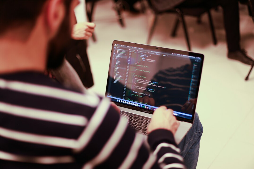 developer writing code on laptop